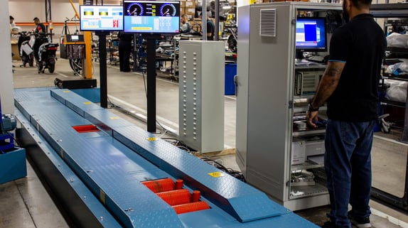 a man standing in a factory with a large screen tv