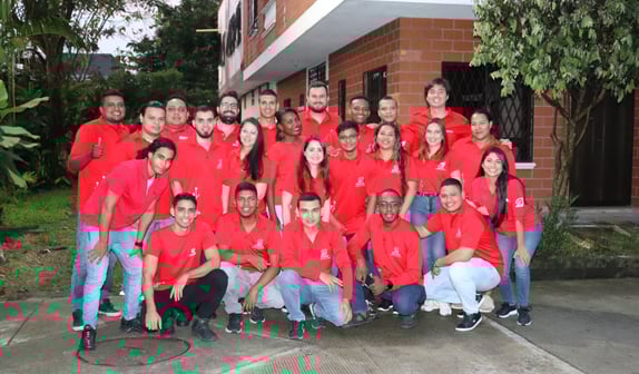 a group of people in red shirts and jeans posing for a group photo