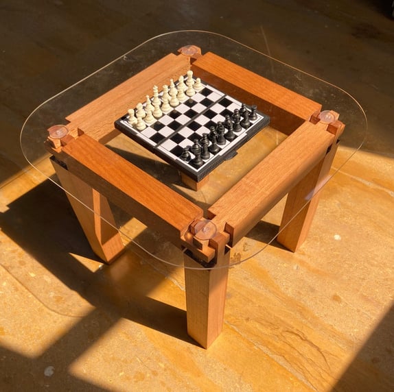 "Handmade hardwood joinery coffee table with curved glass top—modern woodworking by ElkRidge Studio.