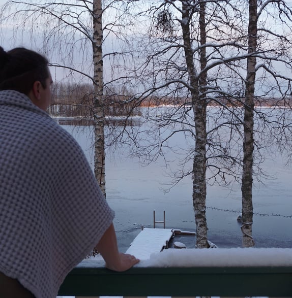 a woman standing on a balcony railing looking out over a lake