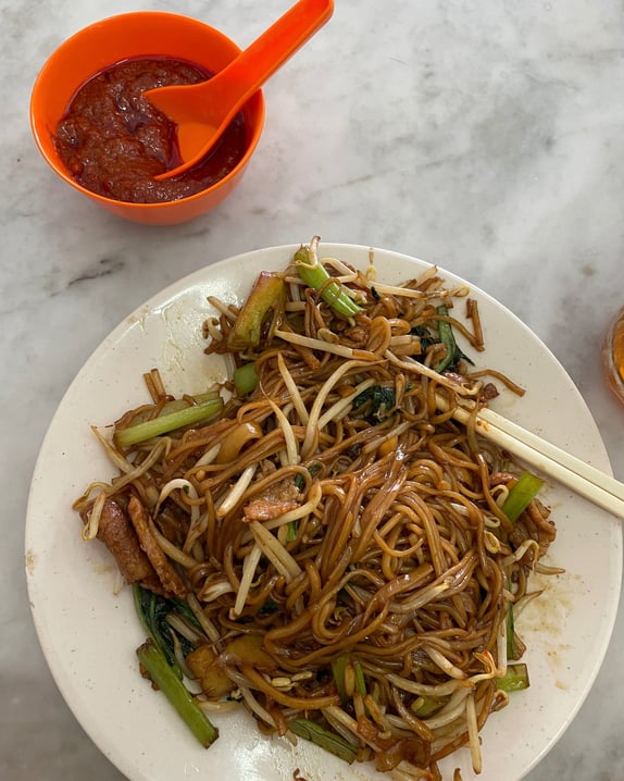 hokkien mee, noodles in a pork lard dark sauce with vegetables and sambal on the side