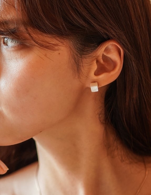 a woman with a pearl necklace and pearl earrings