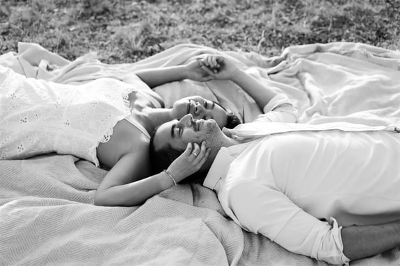 Black and white couple portrait — lying back head to head in a peaceful Provence setting