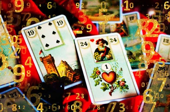 baralho cigano aberto alguns numeros dourados sobre a carta a torre e o coração em destaque