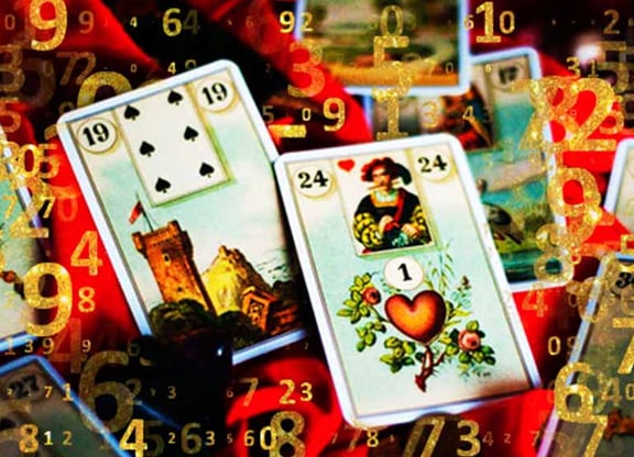 baralho cigano aberto alguns numeros dourados sobre a carta a torre e o coração em destaque