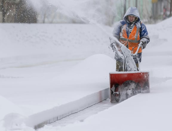 a man is using a snow blower to clear the snow