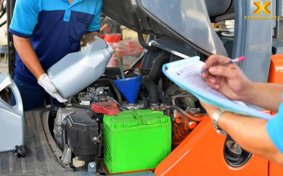 Ảnh 1: Xe nâng đang được bảo dưỡng, kỹ thuật viên kiểm tra các bộ phận