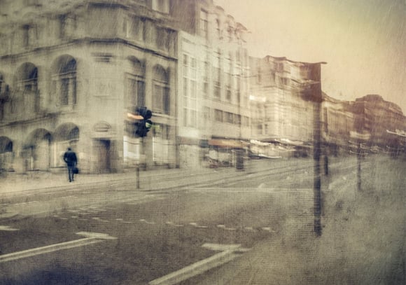 Historic London street scene photographed on a quiet morning with a single pedestrian and traffic light giving direction