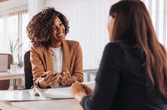 due donne una di fronte l'altra che parlano e sorridono