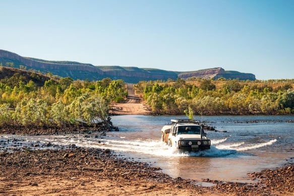 a vehicle driving through a river with a vehicle driving through the water
