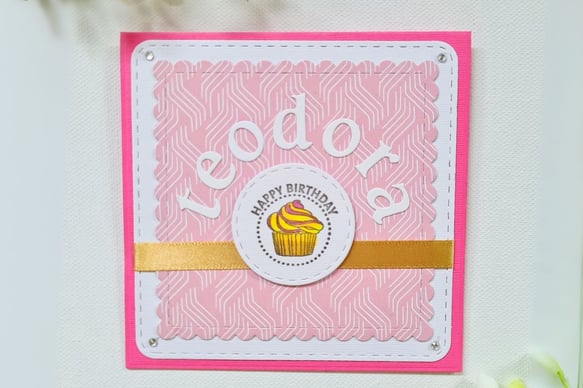Pink birthday card with white border features "Happy Birthday" text and name "Teodora" and a cupcake