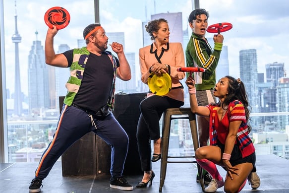 A trio of colourfully dressed frisbee athletes surround a female business executive