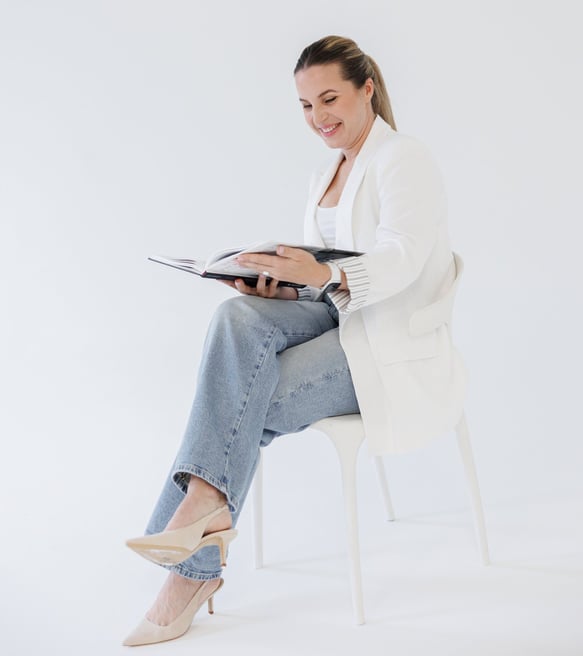 Bilde av grafisk designer Rasa June som sitter på en stol