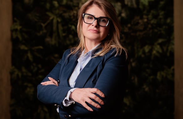 a woman in a suit and glasses posing for a photo