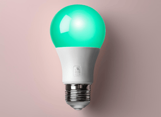 a green light bulb on a light bulb on a pink background