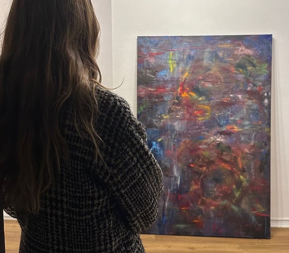 a woman standing in front of a painting