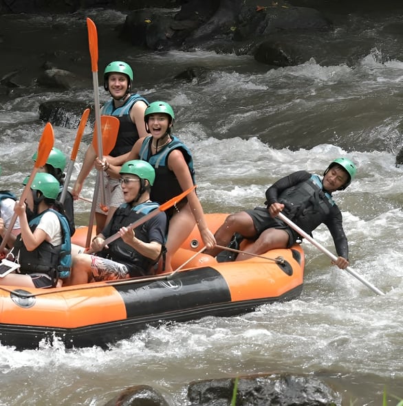 Experienced rafting guide in Ubud Bali helping tourists with safety equipment before river adventure