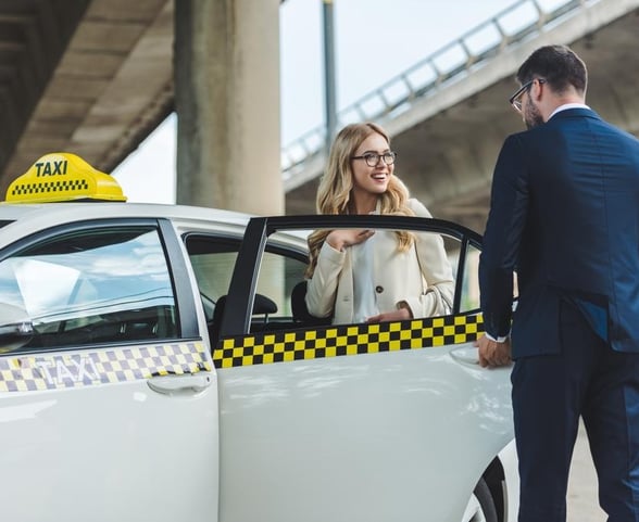 chauffeur bdf ouvre la porte a la cliente en souriant