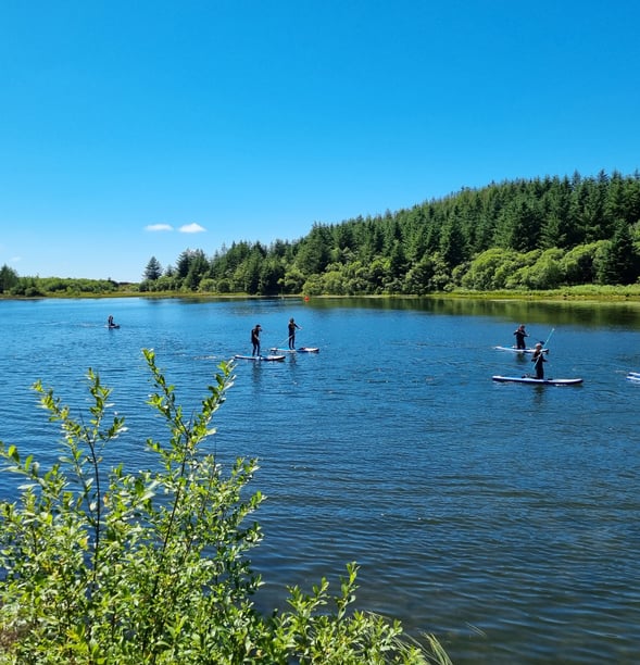 Paddle board lesson on Llyn Pendam with sunny skies