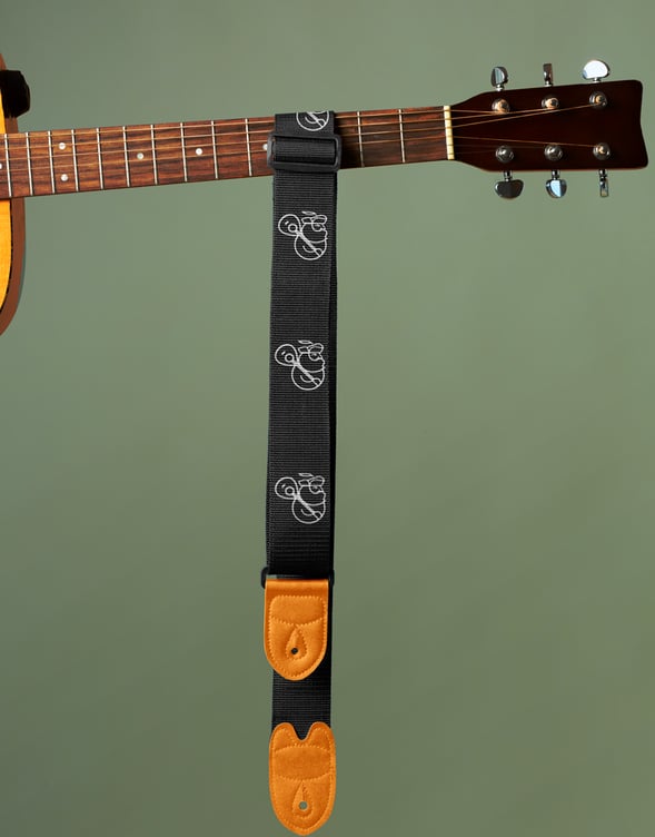 Bandoleira personalizada com logo branco de produtora musical com homem barbudo segurando violão