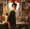 a man in glasses and a green shirt is standing in front of a desk with