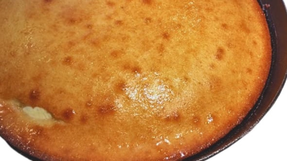 southern style cornbread soaked in butter in an black iron skillet
