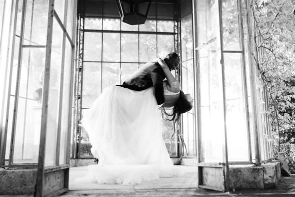 Black and white photo of elopement couple dancing in a glass greenhouse in Provence