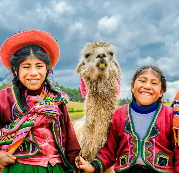 two happy kids from the Andes with a llama.  Dos ninos felices de los Andes con una llama