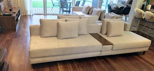 Sofa feito sob medida em linho branco e apoio de braço no meio de madeira