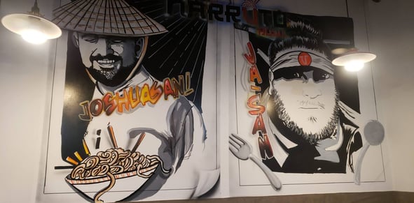 Animated images of the head chefs painted on the wall of a restaurant.