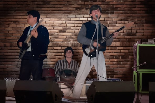 "Los Rockas Surf" a mediados de los. 80's, a group of people standing on stage with guitars