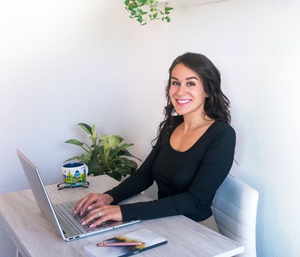 Woman typing on a laptop smiling