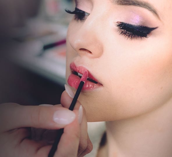 women recieving cosmetic application  of lipstick and facial