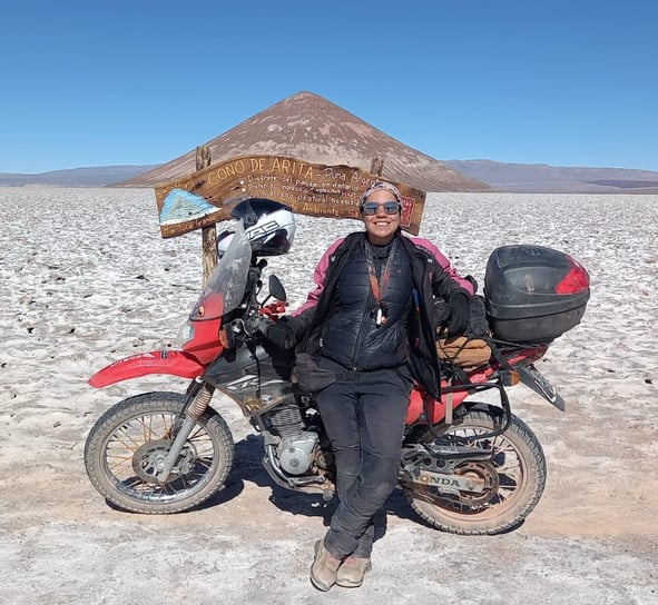 a man sitting on a motorcycle in the desert cono de arita puna atacama salar