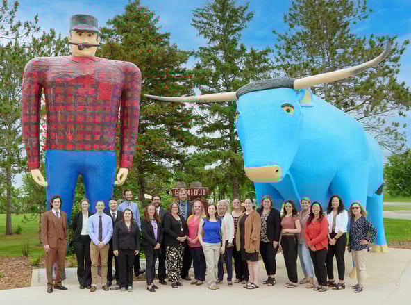 a group of people standing in front of Paul & Babe in Bemidji