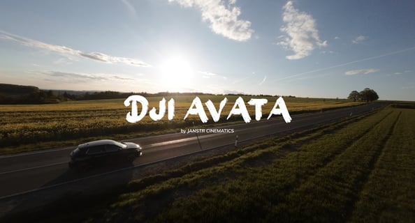 a car driving down a country road with the sun setting behind