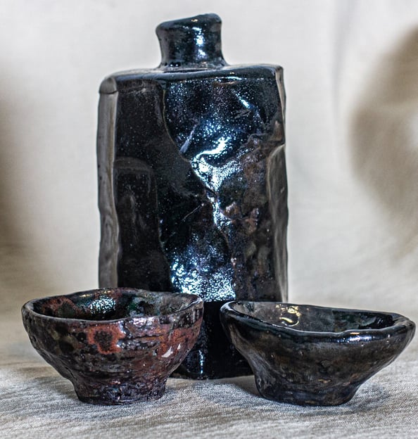 Kurinuki Raku sake set made in Amman, Jordan, hand-carved with black glaze and earthy red tones