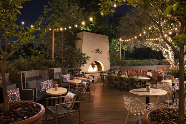 a patio with a fireplace and outdoor seating area from The Garland Hotel