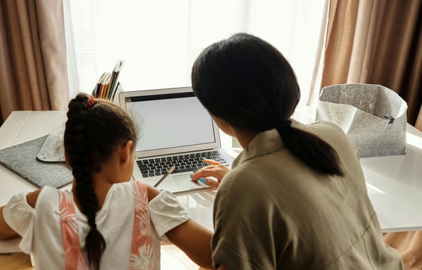 a woman sitting at a table with a laptop computer