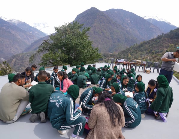 People sitting on the ground amidst mountains