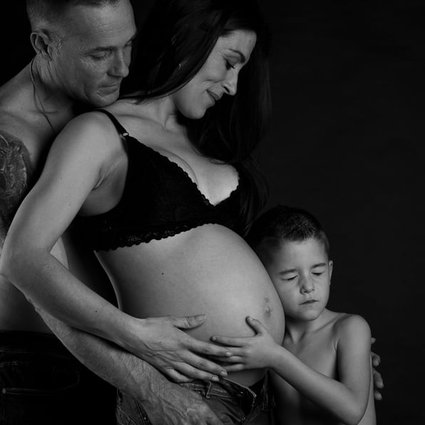 familia tocando la tripa de mama y niño apoyando  la cabeza en la tripa