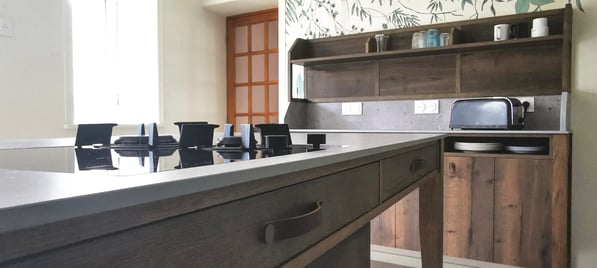 Cuisine bois teinté, meubles beige anti trace de doigts. Ilot central en bois avec dessus pierre.