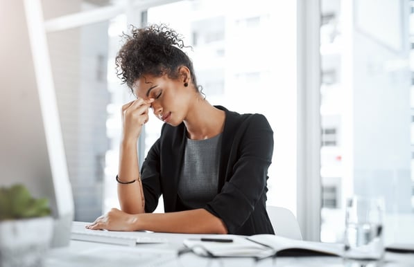 a woman sitting at a desk with a laptop and a notebook