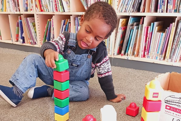Little boy playing with lego blocks at a library