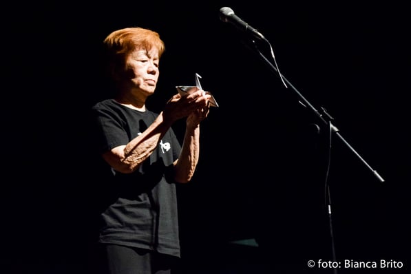 a woman in a black shirt is holding a cell phone