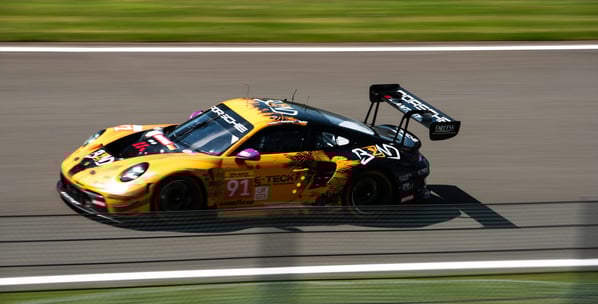 Porsche 911 gt3 gialla e nere durante gara in pista
