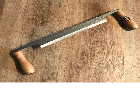 a draw knife on a wooden table