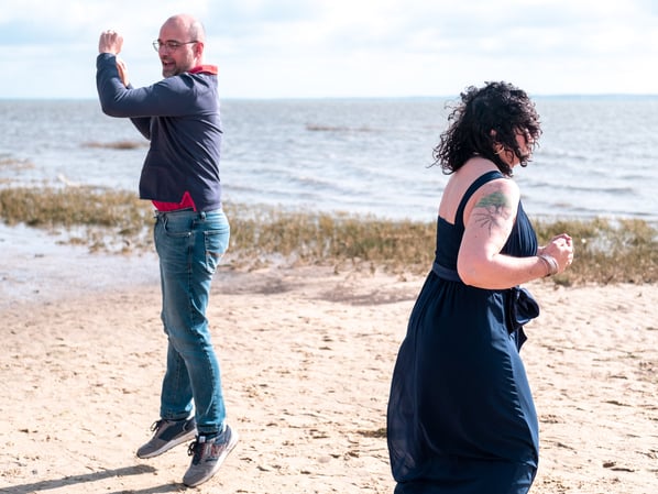 Couple sautant et riant lors d'une séance photo au bassin d'arcachon