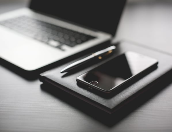 a laptop and a cell phone on a desk