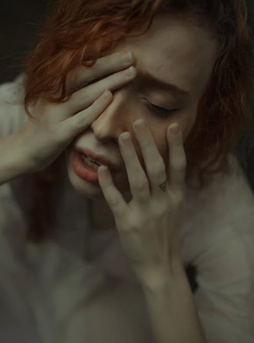 a woman with red hair and a white shirt